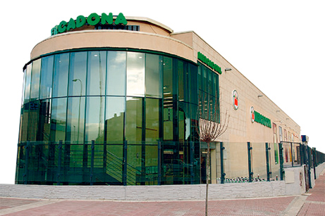 Picture of the outside of a Mercadona store. The inside of the store is displayed, as the majority of the façade is glass.