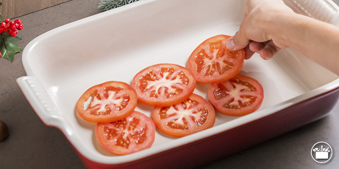 Dispón en una fuente de horno 8 rodajas de tomate.  